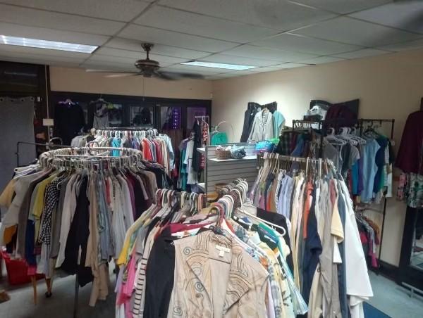 Inside the donation center, with clothing racks and shelves.